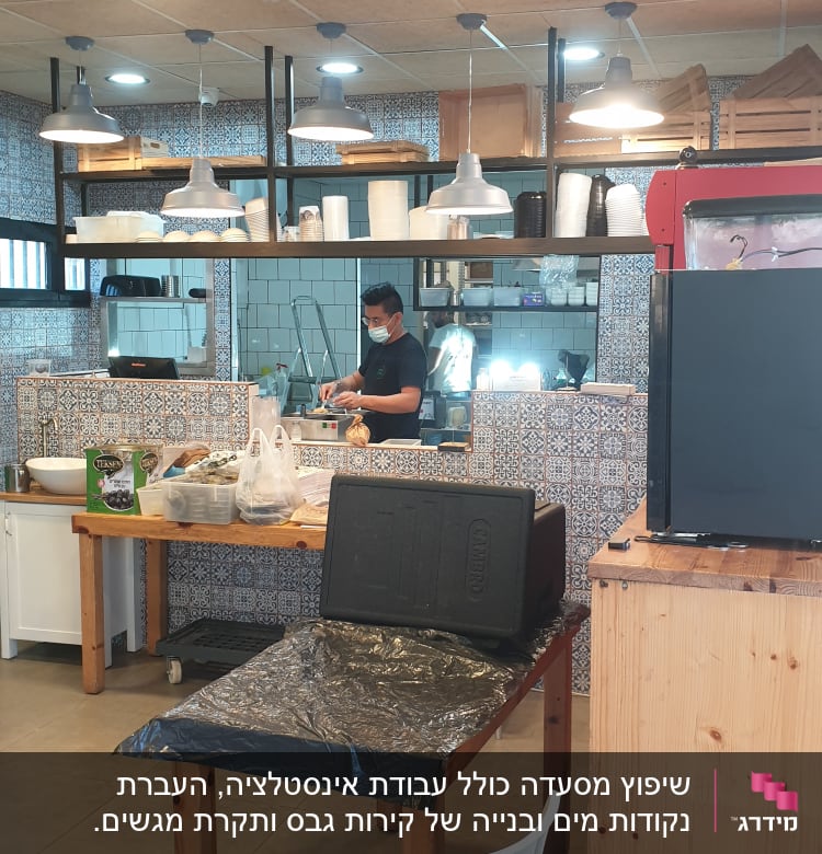 מטבח עם אריחים מעוצבים, שולחן עץ וכלי עבודה